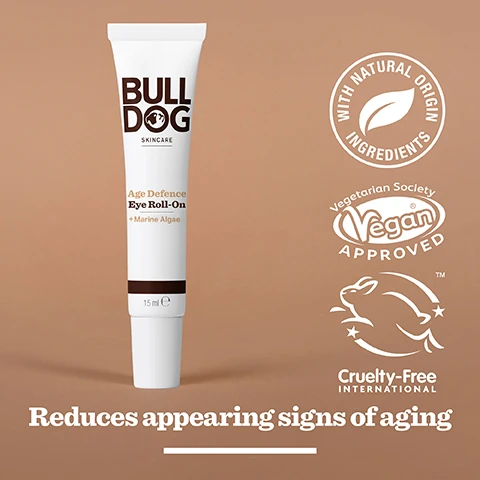 Image 2 - A white tube of Bulldog Skincare Age Defence Eye Roll-On with brown accents, featuring text that includes Age Defence Eye Roll-On, + Marine Algae, 15 ml, and icons indicating vegan approval, cruelty-free status, and natural origin ingredients, along with the phrase reduces appearing signs of aging.
Image 3 - Image of a textured green powder with the text 97% Natural Origin, Unlock the true potential of natural origin ingredients, Marine Algae.
Image 4 - A hand holds a small tube of Bulldog Skincare Age Defence Eye Roll-On with visible text indicating it contains marine algae and is intended for mature skin.
Image 5 - A tube of Bulldog Age Defence Eye Roll-On sits on a marble countertop with text below it stating Reduce the appearance of fine lines and wrinkles.
Image 6 - Three skincare products from Bulldog are displayed on a white surface: an Age Defence Serum, an Age Defence Eye Roll-On, and an Age Defence Moisturiser, with the text Reduce the appearance of fine lines and wrinkles visible beneath them.