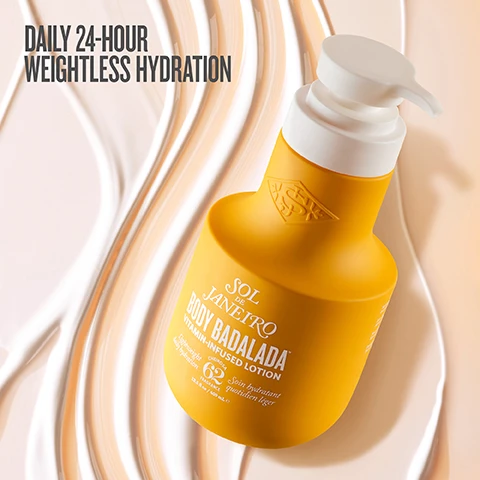 Image 1 - A yellow lotion bottle with a white pump cap is positioned against a swirled background of light cream colors, featuring the text DAILY 24-HOUR WEIGHTLESS HYDRATION at the top and BODY BADALADA VITAMIN-INFUSED LOTION on the bottle.
Image 2 - Image features a green piece of Brazilian sugarcane, a puddle of translucent hyaluronic acid, and a Brazil nut with two halves, accompanied by the text: Brazilian Sugarcane boosts surface hydration, 7 Hyaluronic Acid Blend draws moisture deep, and Brazil Nut Oil nourishes with Vitamin E.
Image 3 - A side-by-side comparison image showing the back of a person wearing a yellow bra; the left side labeled BEFORE displays the skin with visible texture, while the right side labeled AFTER shows smoother skin with the text 95% AGREE SKIN FEELS IMMEDIATELY NOURISHED in the corner.
Image 4 - A popsicle topped with crushed pistachios and swirls of salted caramel, sitting on a light background with visible text reading irresistible scent pistachio salted caramel vanilla.
Image 5 - Image of three bottles of body care products on a marble shelf, including a yellow bottle labeled Brazilian Play Body Wash, a pump bottle labeled Body Badalada Vitamin-Infused Lotion, and a spray bottle labeled 62 Perfume Mist, with the text Unstoppable in 3 Steps, 1 Cleanse & Nourish, 2 Weightlessly Hydrate, 3 Layer the Iconic Scent.
Image 6 - Image shows two skincare products against a yellow background: a pump bottle labeled SOL DE JANEIRO BODY BADALADA with visible text stating weightless lotion for 24-hour hydration, and a jar labeled BRAZILIAN BUM BUM CREAM with visible text stating luscious cream for visibly firm, glowing skin, with creamy swirls above each product.
Image 7 - A close-up image of a hand dispensing a cream from a bottle labeled BODY BALM with visible text stating DERMATOLOGIST TESTED PETA-CERTIFIED ANIMAL TEST-FREE & VEGAN FORMULATED WITHOUT MINERAL OIL PARABENS PHTHALATES.
Image 8 - A flat lay image featuring several yellow-packaged skincare products, including two bottles of Sol de Janeiro Body Badalada lotion and a bottle of Cheirosa 62 perfume mist, with the text that reads Layer on the irresistible with Cheirosa 62™ perfume mist.
Image 9 - A group of women are celebrating outdoors, with one woman in a white bikini and yellow skirt dancing, surrounded by others who are raising their arms; the image includes the text WEIGHTLESS HYDRATION FROM SUNRISE TO AFTER PARTY.
Image 10 - A close-up of a smiling woman with long dark hair, applying moisturizer to her arm, with the text 95% AGREE SKIN FEELS HEALTHY, HYDRATED & SILKY SMOOTH, based on a consumer perception test with 106 participants.