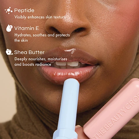 Image 3 - A person with glossy, peachy-pink lips applies a light blue lip product, with text on the left detailing ingredients: Peptide Visibly enhances skin texture, Vitamin E Hydrates, soothes and protects the skin, and Shea Butter Deeply nourishes, moisturises and boosts radiance, while a pink product tube with THE BEAUTY CROP is visible on the right. Image 4 - Several light blue lip balm sticks with red and brown tints are arranged on a light blue background with text that reads: Tinted glossy finish, Leaves lips feeling smooth and plump, and Deeply nourishes and hydrates.